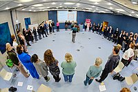 Teilnehmende der Veranstaltung stehen im Kreis